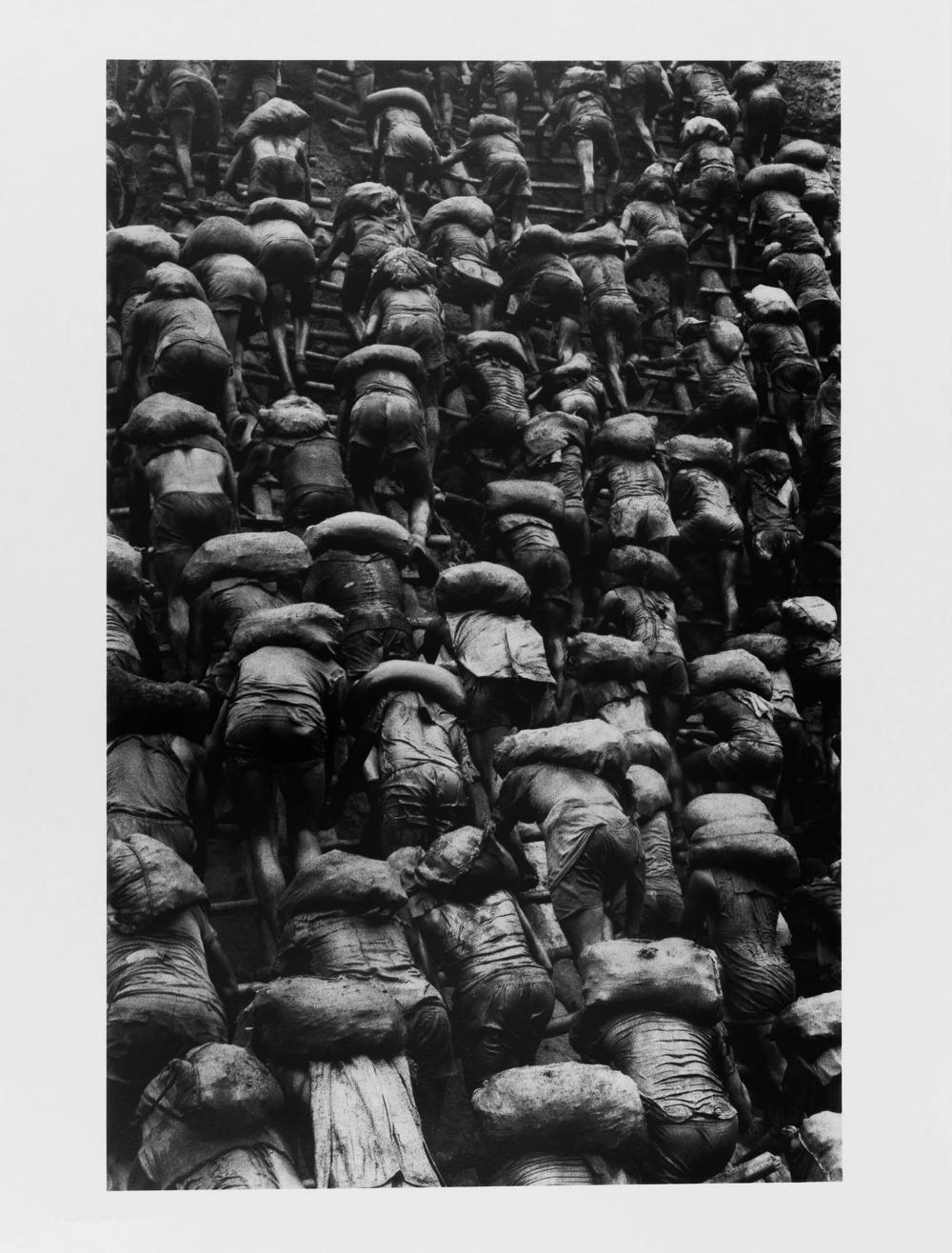 Darbininkai lipa kopėčiomis atviroje kasykloje Serra Peladoje. 1986 metai -- Sebastião Salgado